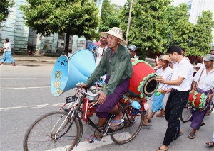 A trishaw driver association parading down Pansodan Street in Yangon, on their way to deliver offerings to a Buddhist monastery.